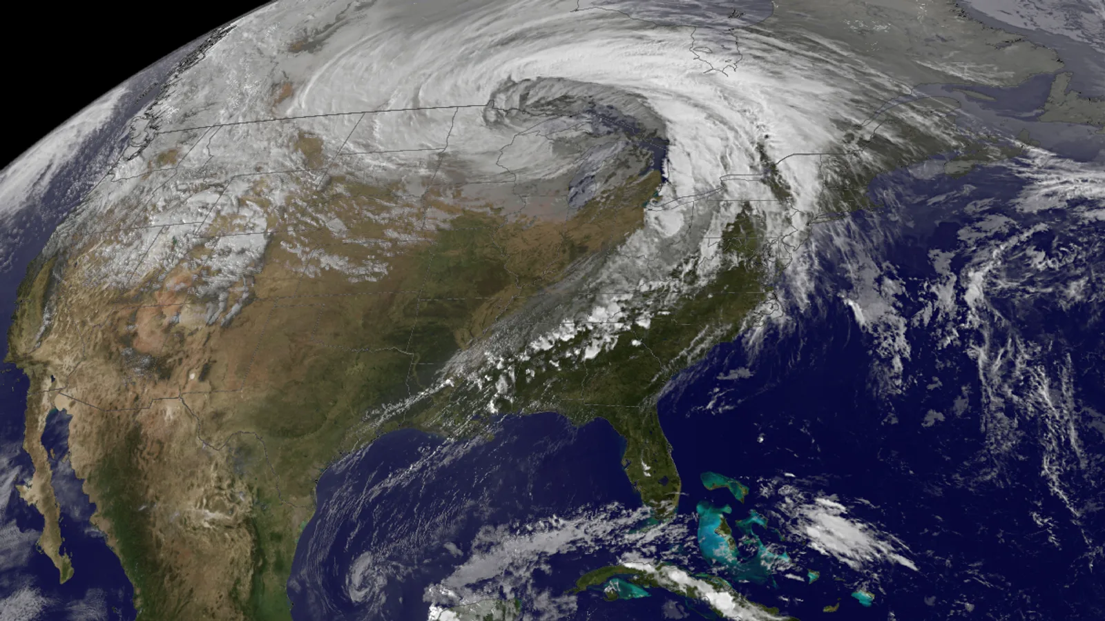 A satellite view of North America with a huge comma-shaped cloud swirling over Minnesota and a long band of cloud trailing south and southwest to the Gulf of Mexico, under a clear sky over the southern Plains and the Southeast.
