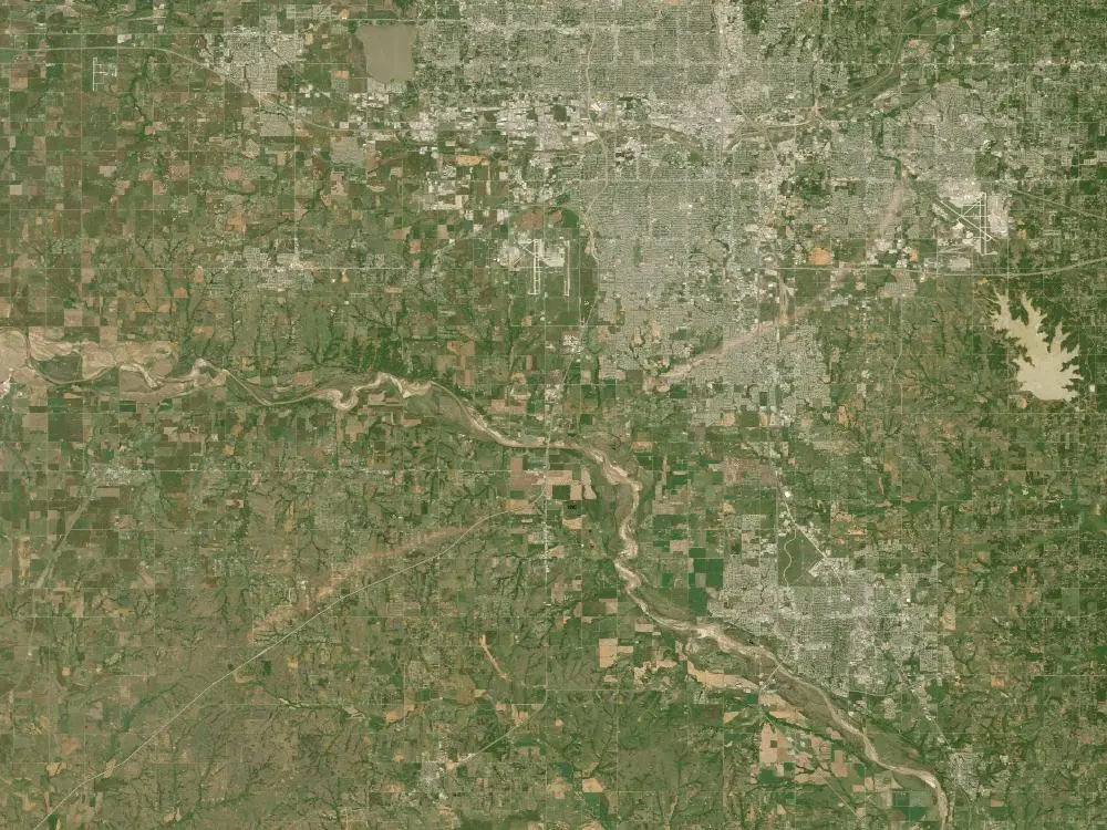 Satellite view of the Oklahoma City area with a pale scar running from lower left toward the suburbs.