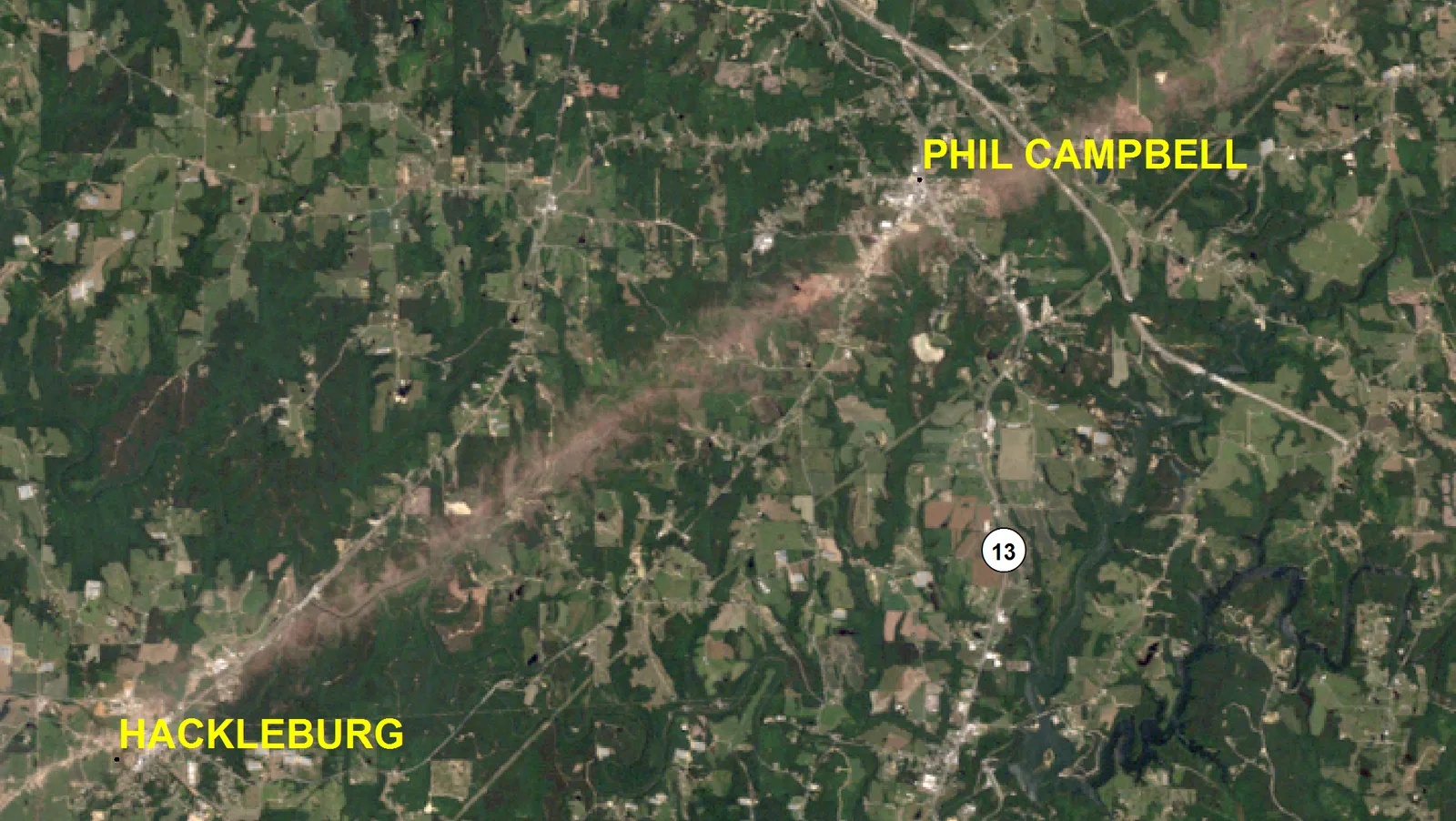 Satellite image of wooded Alabama hills with a pale brown scar running diagonally from Hackleburg at lower left to Phil Campbell at upper right.
