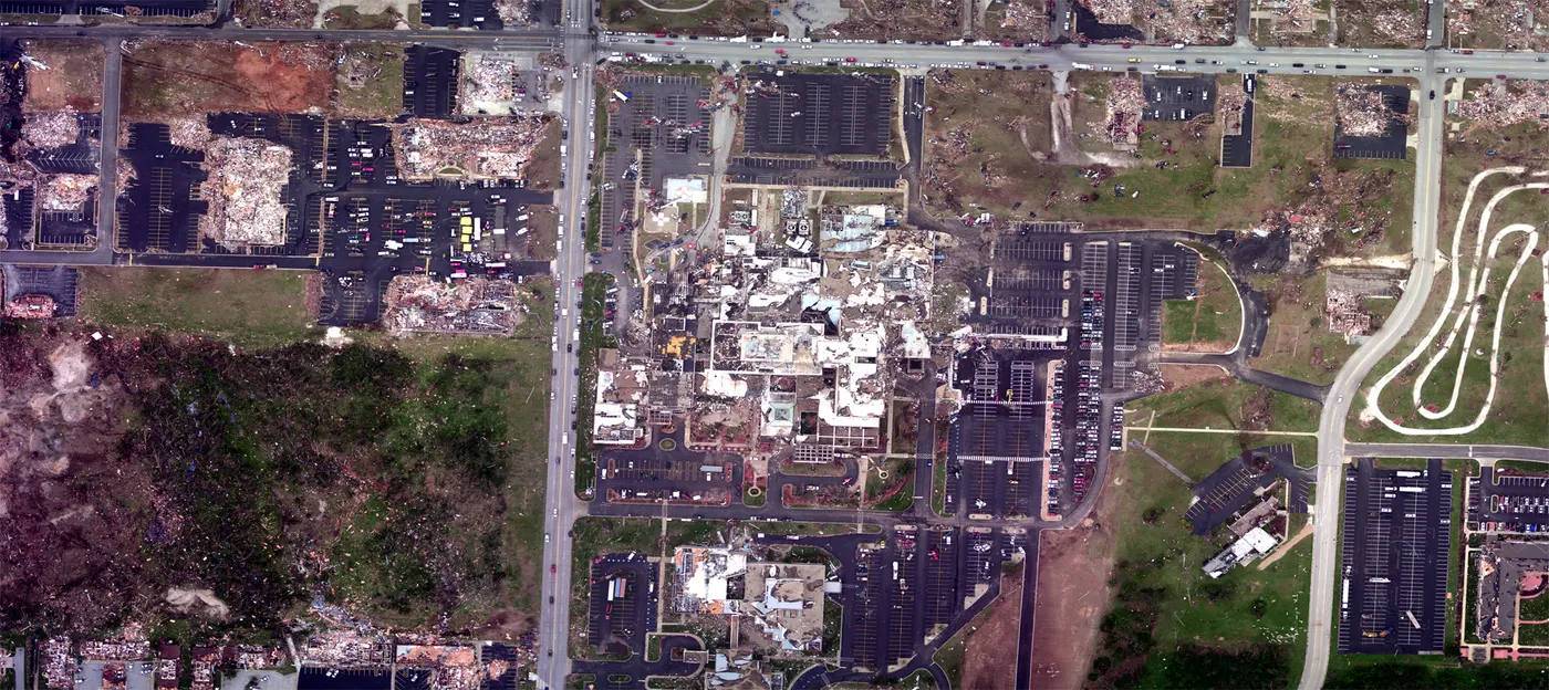 Aerial view of the destroyed St John's Regional Medical Center campus surrounded by flattened city blocks.