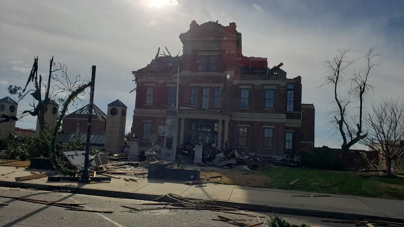 The Graves County Courthouse with its roof and cupola torn away and upper brickwork peeled back.