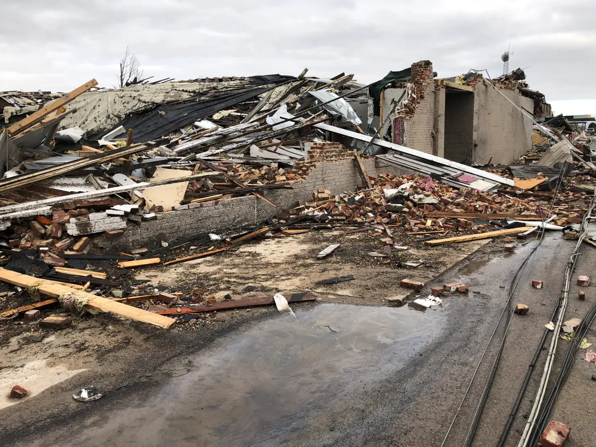 Survey photograph of two well-built brick commercial buildings in downtown Mayfield flattened to their foundations.