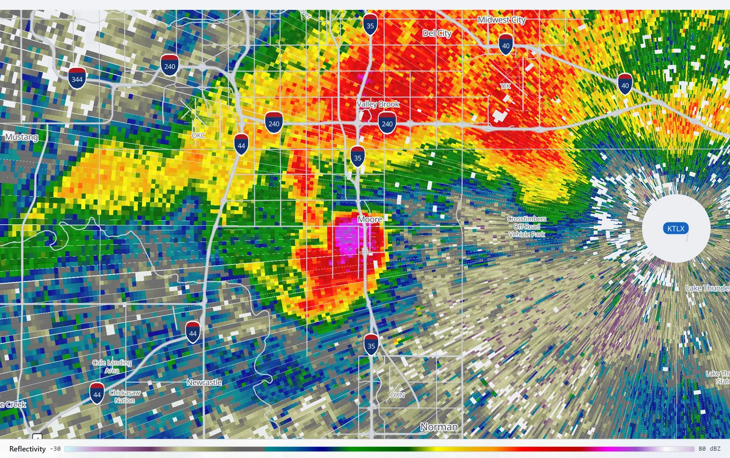 Radar reflectivity over Moore with a hook echo and a bright core at its tip.
