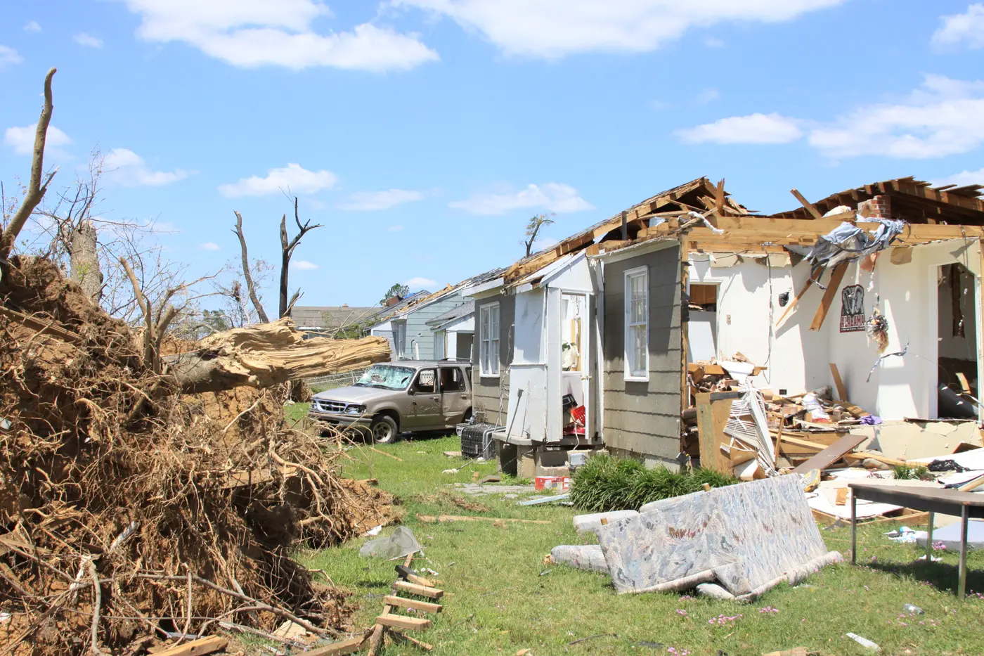 Houses on Cedar Crest Avenue in Tuscaloosa torn open, with debris across the street.