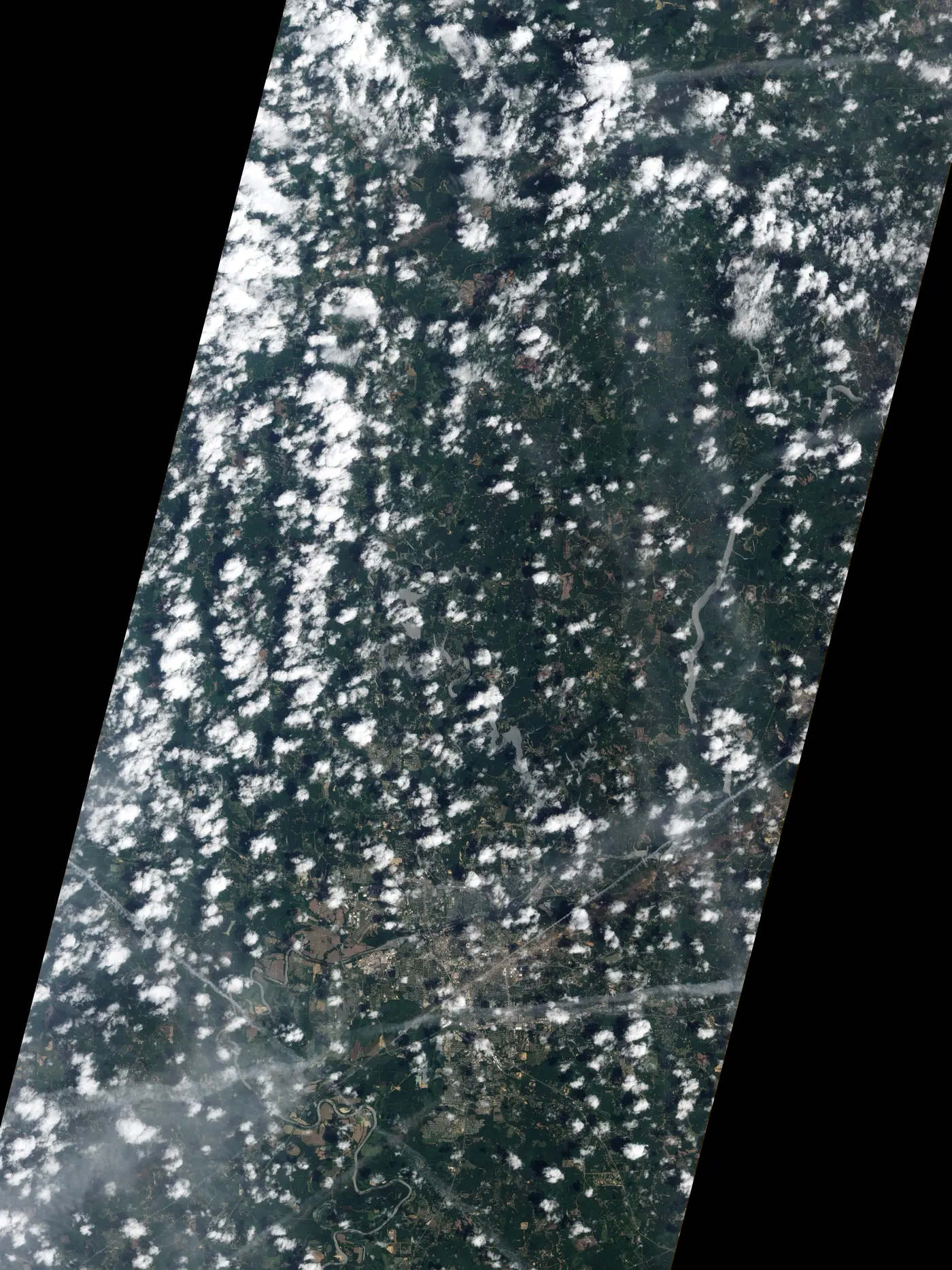 Satellite image of Tuscaloosa with a tan debris-filled track running southwest to northeast through the centre of town.